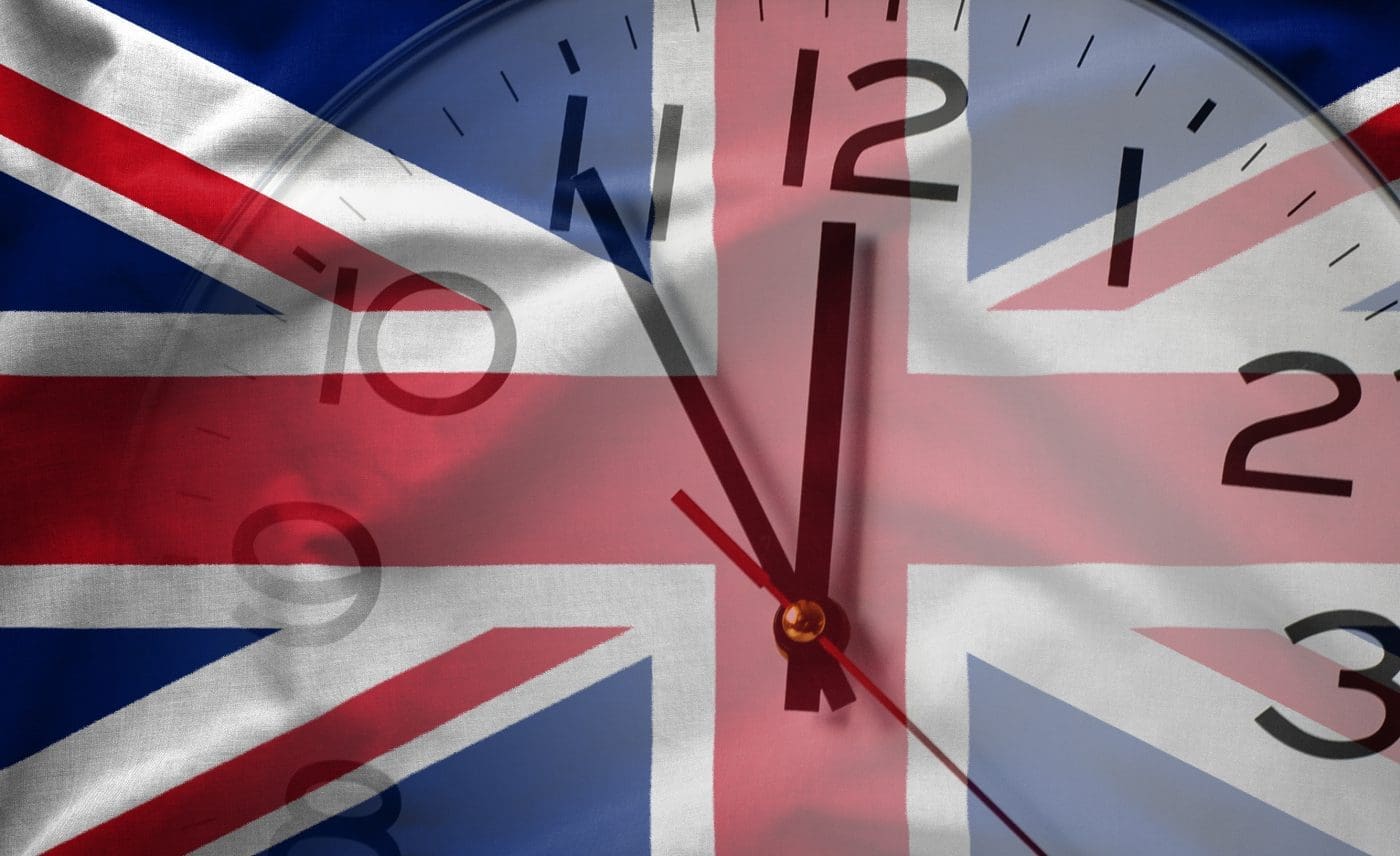 Double exposure of flag of United Kingdom and white clock in concept of Brexit